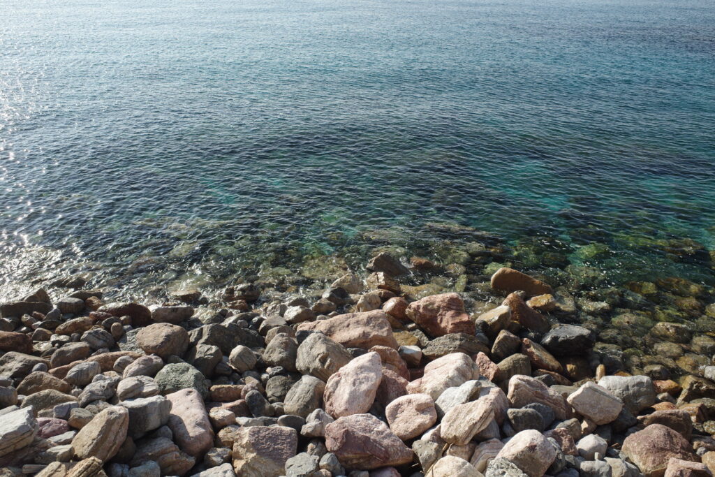 Blue water with coloured stones. Beach in Cinque Terre at Monterroso al Mare.